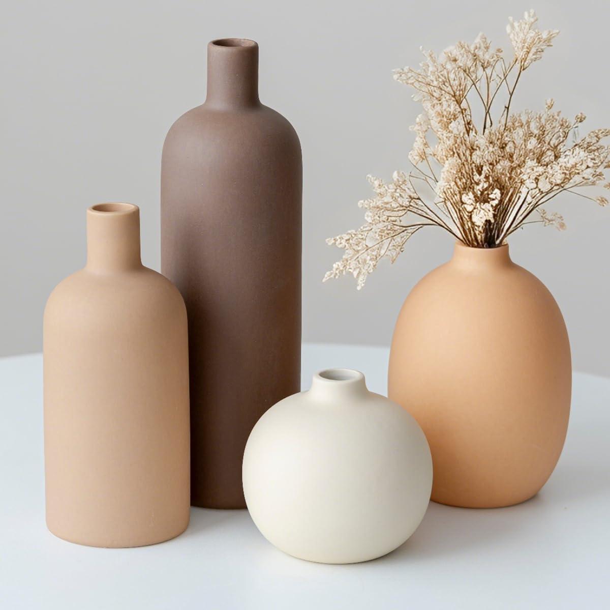 A four-piece modern ceramic vase set in neutral colors styled on a wooden home decor shelf with dried botanicals.