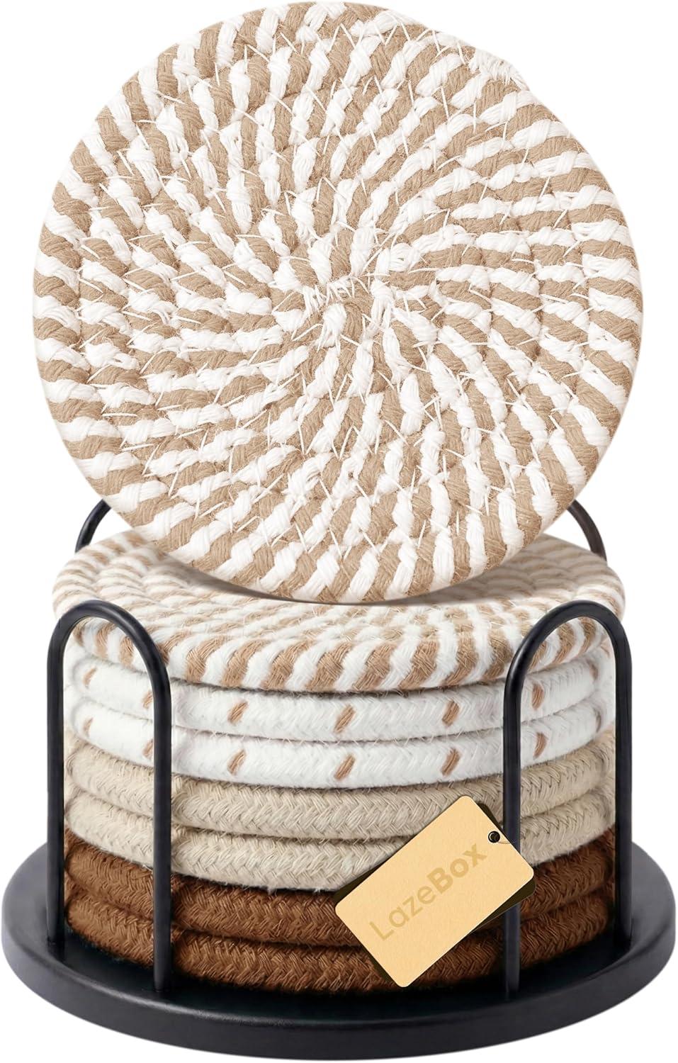 Stacked round woven neutral coasters in beige, cream, and brown tones with a black holder, styled for coffee table decor and tabletop protection.