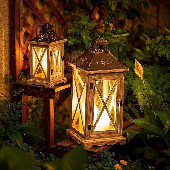 Two distressed wooden candle lanterns glowing warmly in a lush garden at golden hour with plants, wood textures, and cozy rustic patio mood