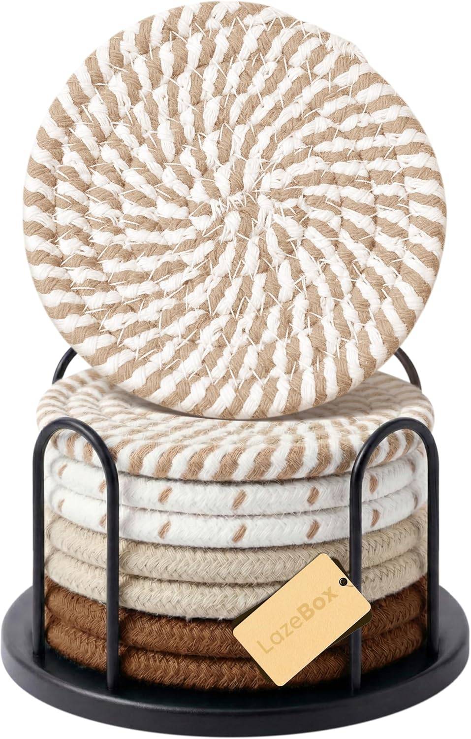 Stacked round woven neutral coasters in beige, cream, and brown tones with a black holder, styled for coffee table decor and tabletop protection.